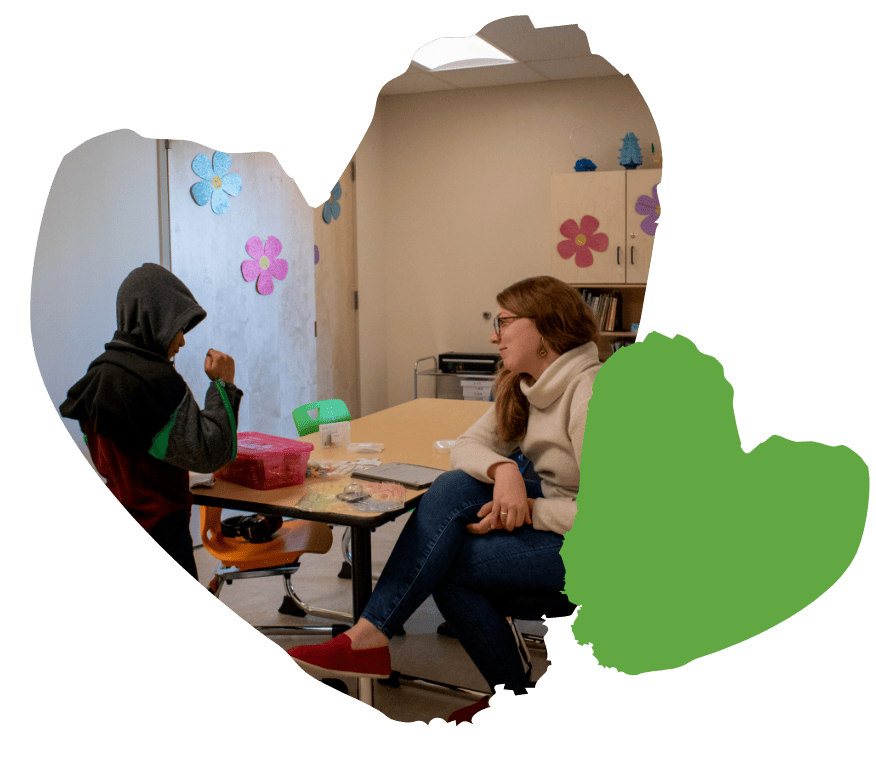student and speech therapist talking in a classroom