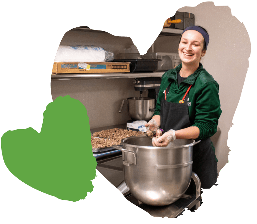spaulding chef smiles while preparing food in kitchen