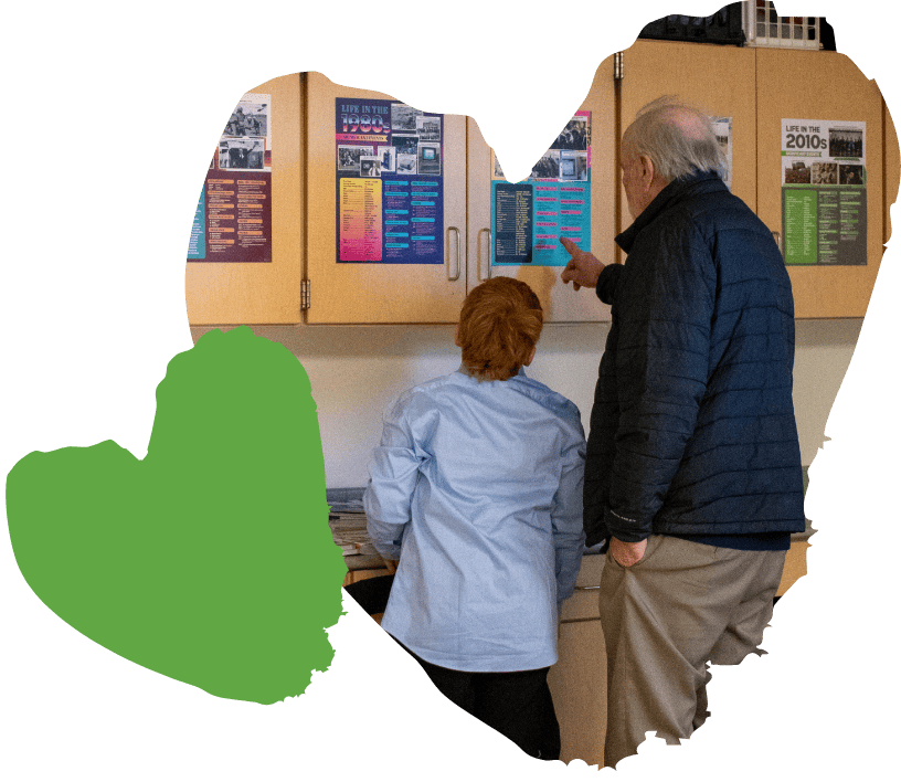 student and adult reading poster on classroom cabinet