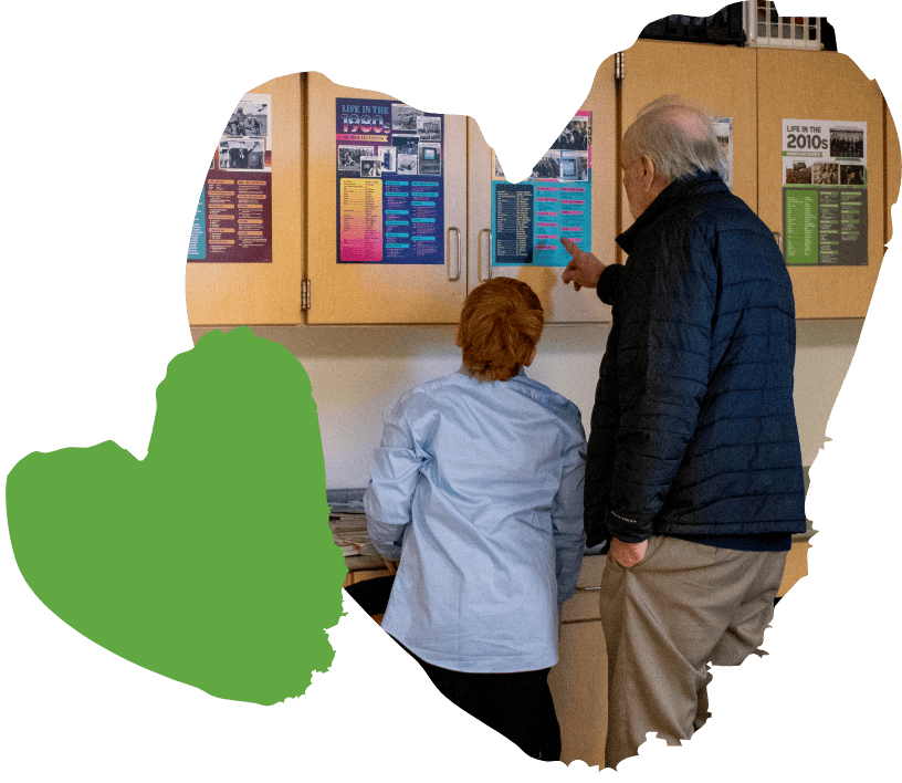 student and adult reading poster on classroom cabinet